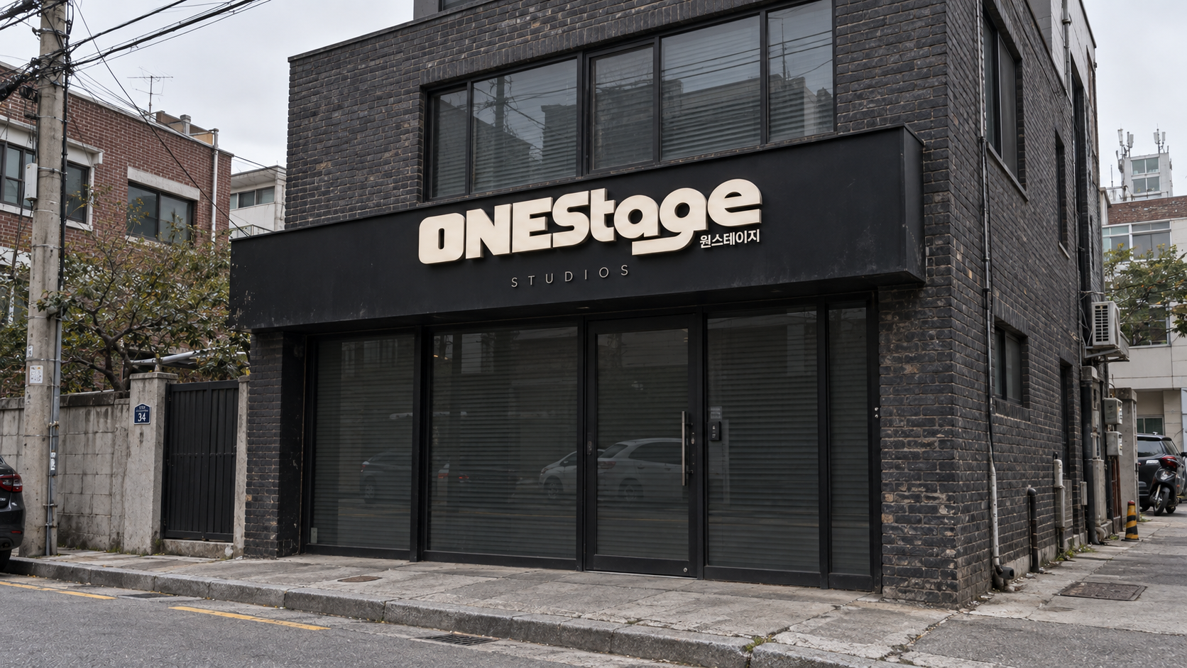Concept of a ONEStage studio in Korea, with ivory signage on a black exterior